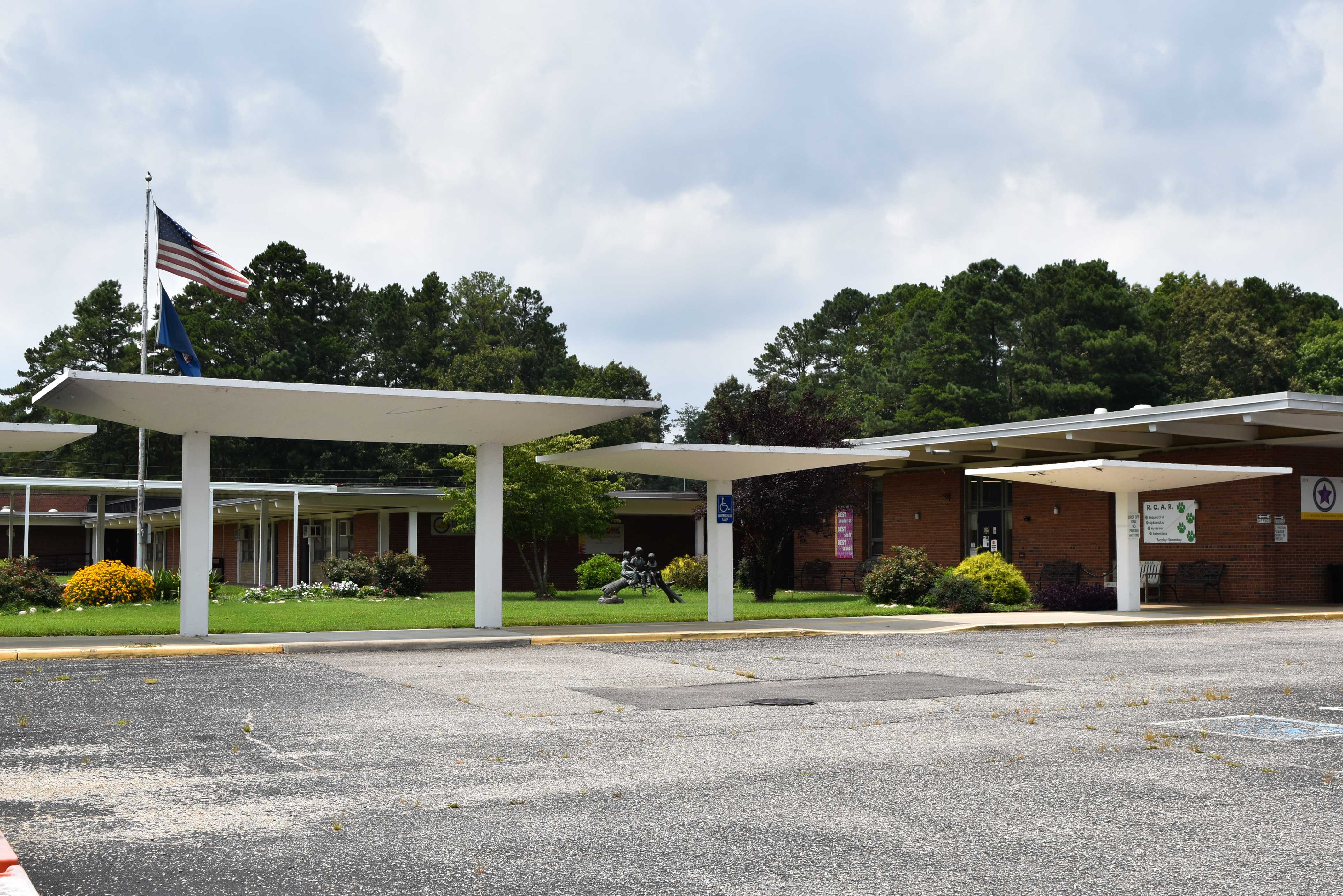 The front facade and white bus loop overhead shading implements are shown.